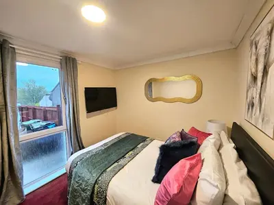 a bedroom with a bed with pillows and a window at 4 bed house With 6 Beds in Edinburgh