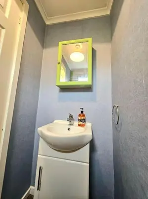 a bathroom with a sink and a mirror at 4 bed house With 6 Beds in Edinburgh