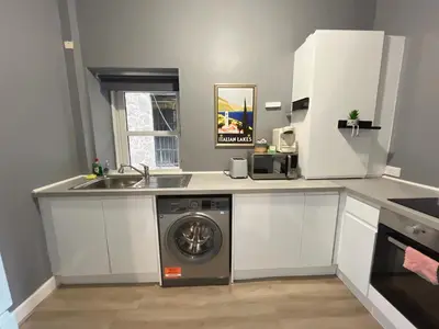 a kitchen with a washing machine and a sink at Two bed apartment in Edinburgh