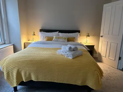 a bedroom with a large bed with towels on it at Two bed apartment in Edinburgh
