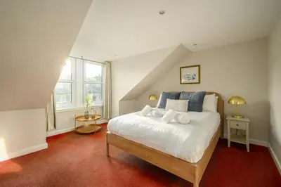 a bedroom with a white bed in a attic at Adam Drysdale House in Edinburgh
