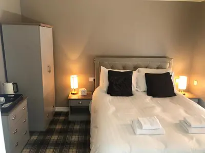 a bedroom with a large white bed with two pillows at The Spinnaker Hotel in Gourock