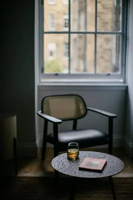 a chair and a table with a glass on it at 33 Castle Terrace in Edinburgh
