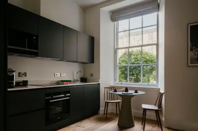 a kitchen with black cabinets and a table and a window at 33 Castle Terrace in Edinburgh