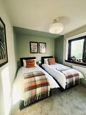 a bedroom with two beds and a window at Castle Gait Apartment in Paisley