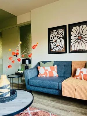 a living room with a blue couch and a table at Castle Gait Apartment in Paisley