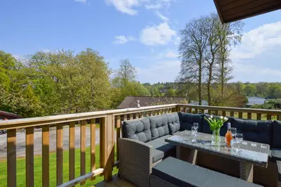 a patio with a table and chairs on a deck at Harris's Cabin in Hunters Quay