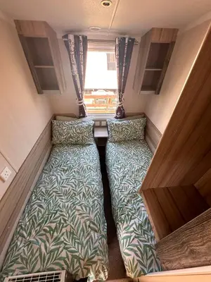 a small room with two beds in a caravan at 3-Bedroom Swift Caravan - Located in Uddingston, Glasgow at Maryville Caravan Site in Glasgow