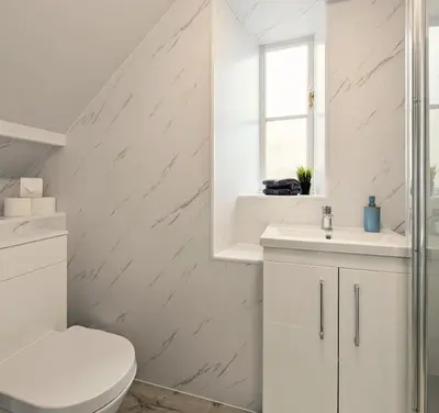 a white bathroom with a toilet and a sink at Campbeltown Central in Campbeltown