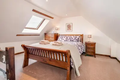 a bedroom with a bed and a window at Courtyard Cottages, Barn Cottage in Wigtown