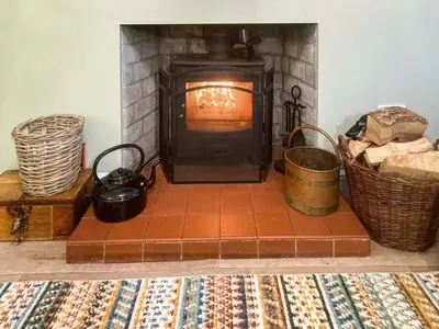 a living room with a fireplace with pots and pans at Darroch in Moniaive