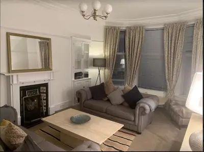 a living room with a couch and a table at airport appartment in Paisley