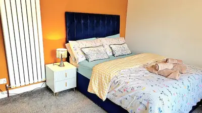 a bed with a blue headboard in a bedroom at The Rest in Tarbert