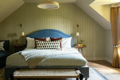 a bedroom with a bed with a blue headboard at Penicuik Estate in Penicuik