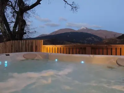 a jacuzzi tub with a view of mountains at Hot tub lodge with stunning view in Taynuilt