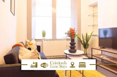 a living room with a couch and a tv at 1 BDR Apartment By Caledonia Luxe Stays Short Lets & Serviced Accommodation in Dumbarton