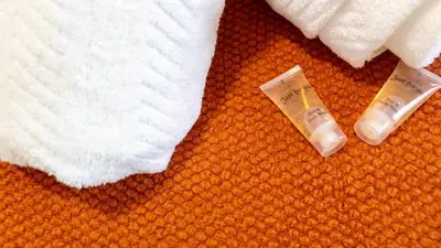 a pair of tubes of toothpaste and towels on a bed at 1 BDR Apartment By Caledonia Luxe Stays Short Lets & Serviced Accommodation in Dumbarton