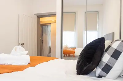 a bedroom with a bed and a mirror at 1 BDR Apartment By Caledonia Luxe Stays Short Lets & Serviced Accommodation in Dumbarton