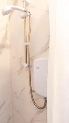 a shower with a shower head in a bathroom at 1 BDR Apartment By Caledonia Luxe Stays Short Lets & Serviced Accommodation in Dumbarton