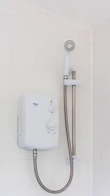 a shower in a white tiled bathroom with a shower at Blairmuire House in Broxburn