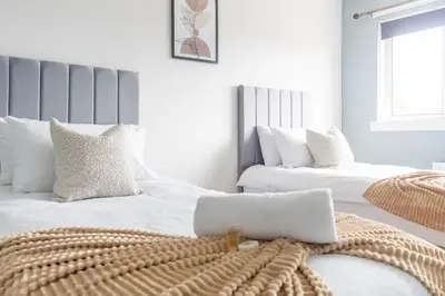 a bedroom with two beds with white pillows at Blairmuire House in Broxburn
