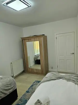 a bedroom with a mirror and a bed in it at Lovely house with private parking! Glasgow! in Glasgow