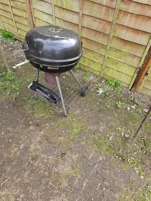 a grill sitting in the grass in a yard at Lovely house with private parking! Glasgow! in Glasgow