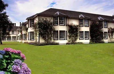 a large house with a green lawn in front of it at Green Hotel, a member of Radisson Individuals in Kinross