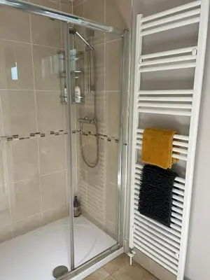 a shower with a glass shower stall in a bathroom at Riverbank Lodge in Dollar