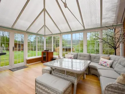 a living room with a couch and a table at Nether Auchlinsky Cottage in Glendevon