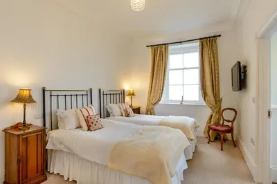 two beds in a bedroom with a window at Alexander House 24 - Self Catering in Auchterarder