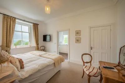 a bedroom with a bed and a desk and a window at Alexander House 24 - Self Catering in Auchterarder