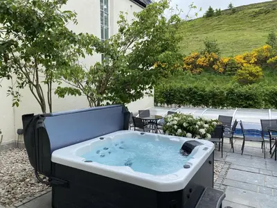a jacuzzi tub in a yard with a table at Alexander House 24 - Self Catering in Auchterarder