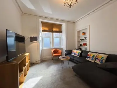 a living room with a couch and a tv at Lovely two bedrooms in Edinburgh