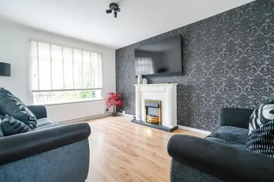 a living room with two couches and a fireplace at Livingston 4 Bed + Car Space in Livingston