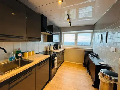 a kitchen with a sink and a stove top oven at Top Floor of the building, spectacular views! in Glasgow