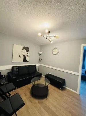 a living room with a black couch and a table at Top Floor of the building, spectacular views! in Glasgow