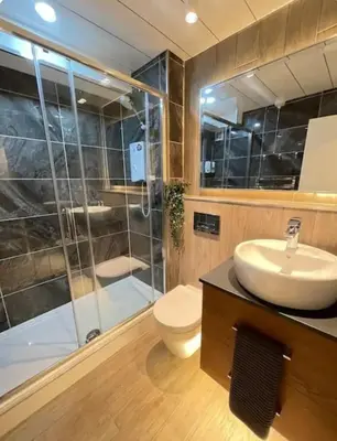 a bathroom with a toilet and a sink and a shower at Top Floor of the building, spectacular views! in Glasgow