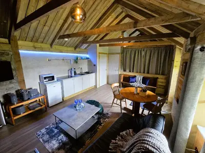 a living room with a table and a kitchen at Ard Veich Estate - Panoramic Highland Sea Views with private beach and woodland in Port Appin