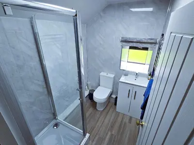 a bathroom with a shower and a toilet and a sink at Ard Veich Estate - Panoramic Highland Sea Views with private beach and woodland in Port Appin