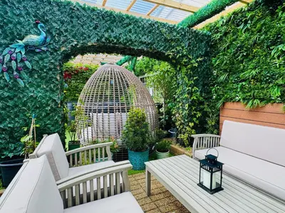 a garden with two benches and a birdiary at FINN VILLAGE - Loch Lomond Villa - THE JUNGLE ROOM with a PRIVATE HOT TUB in Drymen