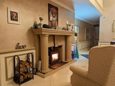 a living room with a fireplace and a chair at FINN VILLAGE - Loch Lomond Villa - THE JUNGLE ROOM with a PRIVATE HOT TUB in Drymen