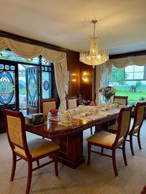 a dining room with a table with chairs and a chandelier at FINN VILLAGE - Loch Lomond Villa - THE JUNGLE ROOM with a PRIVATE HOT TUB in Drymen