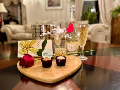 a wooden cutting board with cupcakes and a bottle of champagne at FINN VILLAGE - Loch Lomond Villa - THE JUNGLE ROOM with a PRIVATE HOT TUB in Drymen