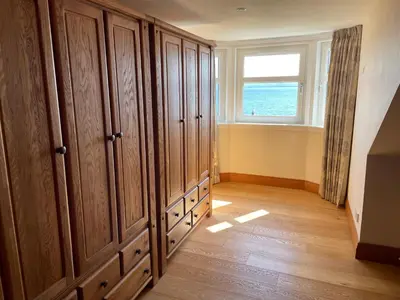 a room with wooden cabinets and a window at Inverbeg Cottage in Rothesay