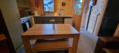 a small kitchen with a wooden table in a cabin at 2 bed Lodge near Dunoon on the Shore Front in Dunoon