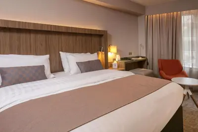 a hotel room with a large bed and a chair at Best Western Motherwell Centre Moorings Hotel in Motherwell