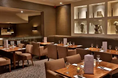 a dining room with wooden tables and chairs at Best Western Motherwell Centre Moorings Hotel in Motherwell