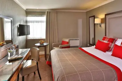 a hotel room with a large bed and a table at Best Western Motherwell Centre Moorings Hotel in Motherwell
