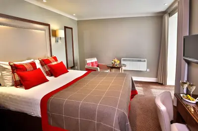a hotel room with a large bed with red pillows at Best Western Motherwell Centre Moorings Hotel in Motherwell